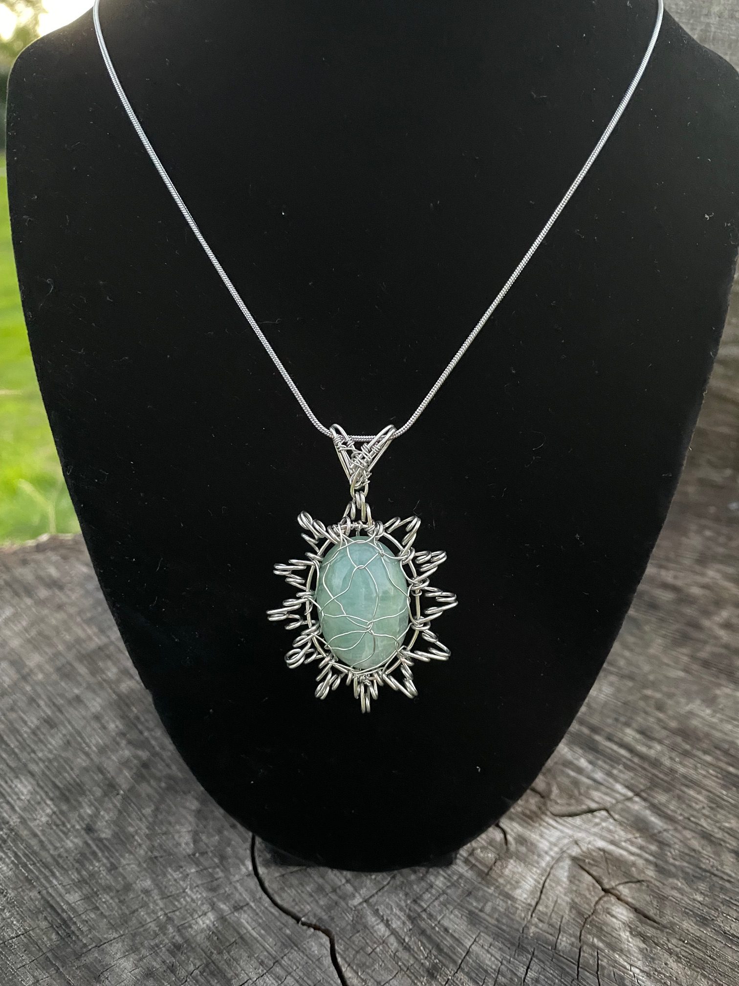 Star Aquamarine Aquamarine Cabochon stone with silver colour wire. The pendant shape is like a star